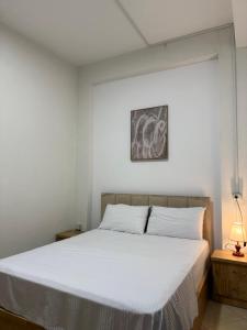 a bedroom with a bed with a white bedspread at ORA Appartment's in Shkodër +17 photos