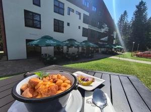 a bowl of food sitting on a table in front of a building at Mountain-Rest Pension in Miercurea-Ciuc
