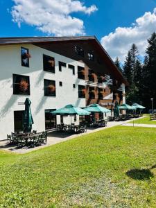a building with tables and umbrellas in front of it at Mountain-Rest Pension in Miercurea-Ciuc