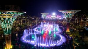 a fountain in the middle of a city at night at The Pathway Condotel in Sầm Sơn