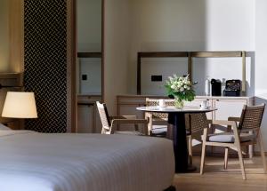 a hotel room with a table and chairs and a bed at Chatrium Phuket Rawai in Rawai Beach +118 photos