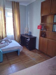 a bedroom with a bed and a dresser and a desk at Lalo in Tbilisi City