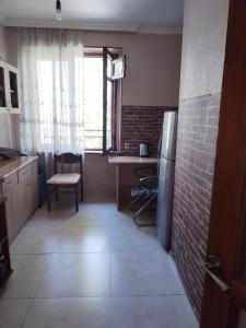 a kitchen with a refrigerator and a table and a window at Lalo in Tbilisi City