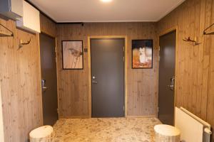 a hallway with wooden walls and a door with two stools at Camp Gielas, Arvidsjaur in Arvidsjaur +45 photos