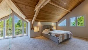 a bedroom with a bed in a room with windows at Villa Panoramique - Lac du Bourget in Bourdeau