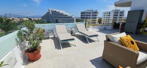 a balcony with chairs and tables on a building at Mar & Sol Penthouse in Portimão
