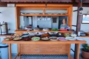 a woman standing behind a table with food on it at CARETTA PANSİYOn in Kaş