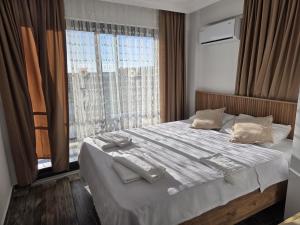 a bedroom with a bed with white sheets and a window at CARETTA PANSİYOn in Kaş