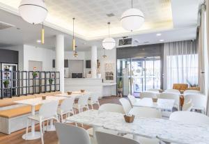 a restaurant with white tables and white chairs at B&B HOTEL Marseille Centre La Timone in Marseille