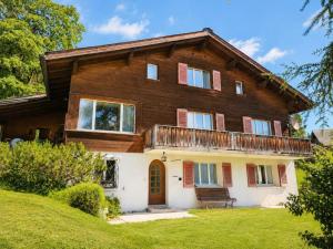 a large wooden house on a green lawn at Revier Lärchenglück in Braunwald