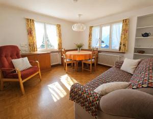a living room with a couch and a table and chairs at Revier Lärchenglück in Braunwald