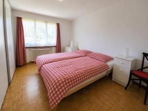 a bedroom with a bed with a red and white blanket at Revier Lärchenglück in Braunwald