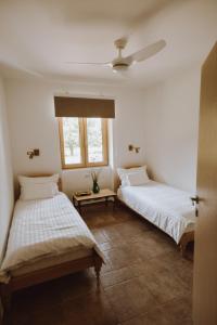two beds in a room with two windows at Nizija in Sombor