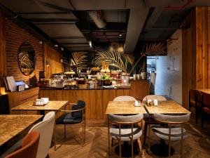 a restaurant with tables and chairs and a kitchen at Citadines Salcedo Makati in Manila