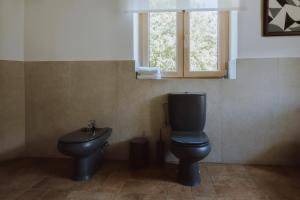 a bathroom with a toilet and a sink and a window at Nizija in Sombor +25 photos