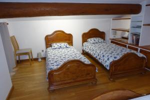 a bedroom with two beds and a chair at Chambre dans maison provençale avec piscine in Cavaillon +15 photos