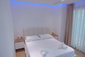 a bedroom with two beds with white sheets and a window at Seaview Premium Apartment in Durrës