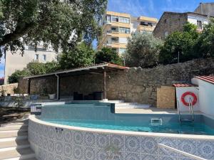 a swimming pool with a building in the background at Quintal de São Marcos in Castelo Branco