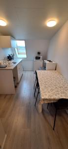 a room with a table and a kitchen with a counter at Cottage in the middle of nowhere 2 in Ölfus