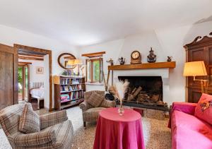 a living room with a red table in front of a fireplace at Vicinato Homestead in Molazzana