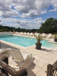 a swimming pool with lounge chairs and a swimming pool at La Croix Gîtes in Pressignac