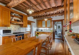 a kitchen with wooden cabinets and a wooden table at Vicinato Homestead in Molazzana