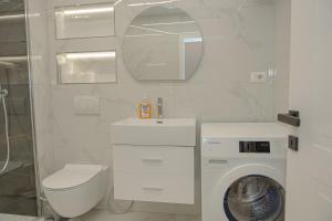 a white bathroom with a washing machine in it at Seaview Premium Apartment in Durrës +16 photos