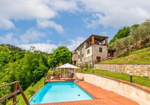 a swimming pool in front of a building with a house at Vicinato Homestead in Molazzana