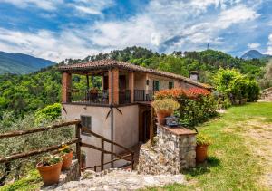a small house with a balcony on a hill at Vicinato Homestead in Molazzana
