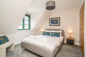 a bedroom with a bed and a couch and a chair at A beautiful mews house in a city centre in Edinburgh