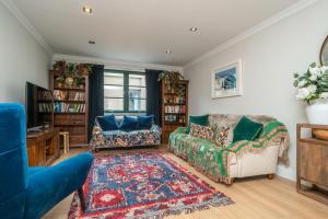 a living room with two couches and a rug at A beautiful mews house in a city centre in Edinburgh