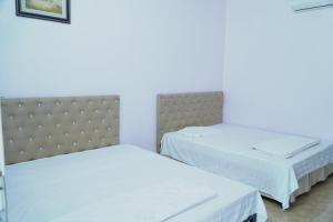 two beds in a room with white walls at Ngày Mới Hotel in Nghĩa Lộ