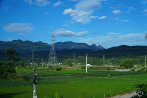 a electricity tower in a field with mountains in the background at Ngày Mới Hotel in Nghĩa Lộ +11 photos