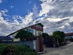 a white building with a fence in front of it at Ngày Mới Hotel in Nghĩa Lộ