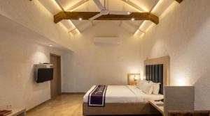 a bedroom with a bed and a television in a room at Nostravila Resort and Spa in Lonavala
