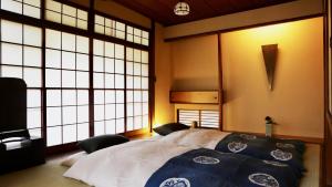 a bedroom with a large bed and large windows at 一日一組 湘南の古民家貸別荘 Traditional Beach Villa, Quiet Seaside Stay, 10min Walk to Beach in Chigasaki