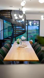 a long wooden table with chairs and a staircase at Pensiunea Qubik Praid in Ocna de Jos