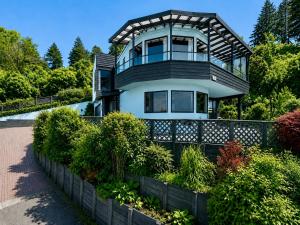 a large house with a balcony on top of it at Serendipity with a view in Taupo