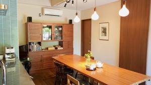a dining room with a wooden table and a cabinet at 一日一組 湘南の古民家貸別荘 Traditional Beach Villa, Quiet Seaside Stay, 10min Walk to Beach in Chigasaki