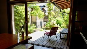 a patio with a chair on a wooden deck at 一日一組 湘南の古民家貸別荘 Traditional Beach Villa, Quiet Seaside Stay, 10min Walk to Beach in Chigasaki