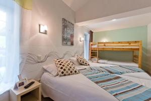 a bedroom with two beds and a bunk bed at Logis Hôtel Restaurant de la Dore in Vertolaye