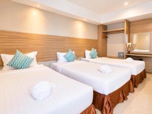 a row of three beds in a room at Avana Laem Chabang Boutique Hotel in Ban Laem Chabang
