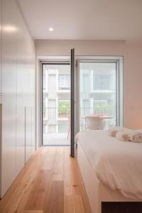 a bedroom with a bed and a large window at Aposentus - Sal D 'Ouro Exclusive in Canidelo