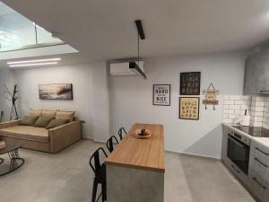 a kitchen and living room with a couch and a table at Alkaiou Loft in Kalamata +13 photos