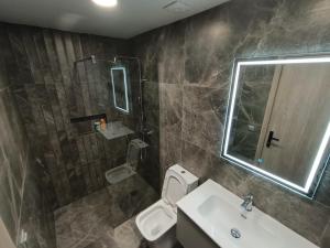 a bathroom with a toilet and a sink and a shower at Alkaiou Loft in Kalamata