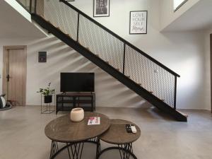 a living room with two tables and a staircase at Alkaiou Loft in Kalamata