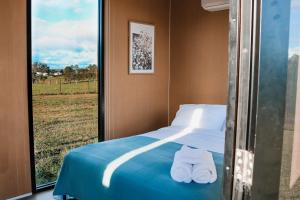 a bedroom with a bed with towels on it at Pasture and Paws by Tiny Away in Leeville