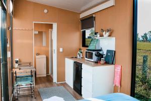 a small kitchen with a counter and a microwave at Pasture and Paws by Tiny Away in Leeville
