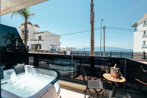 a hot tub on a balcony with a table and chairs at Heavenly Rest Luxury Hotel in Sarandë