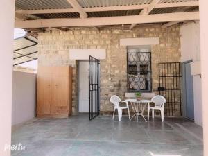 a dining room with a table and chairs and a brick wall at Keetmanshoop Self-catering in Keetmanshoop